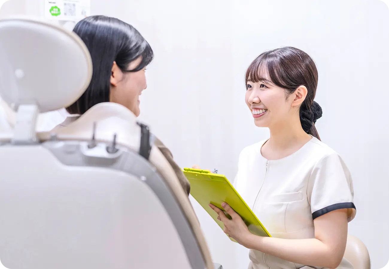 カウンセリングルームで患者の話を笑顔で聞く歯科助手